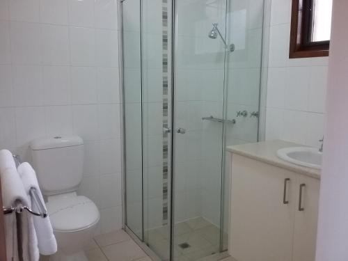 a bathroom with a shower and a toilet and a sink at Werribee Park Motor Inn in Werribee