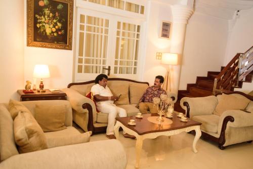 a man and a woman sitting in a living room at Kandy view resort in Kandy