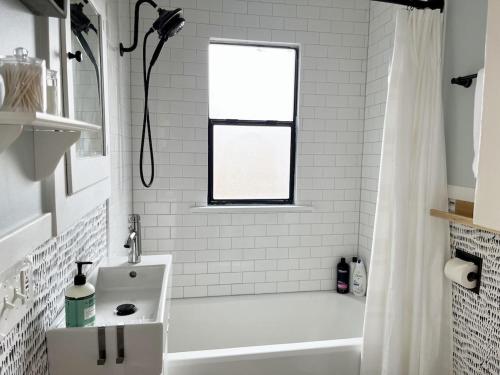 uma casa de banho branca com uma banheira e um chuveiro em Modern 2 Bedroom Farmhouse Cottage with Hot Tub in Snohomish em Snohomish