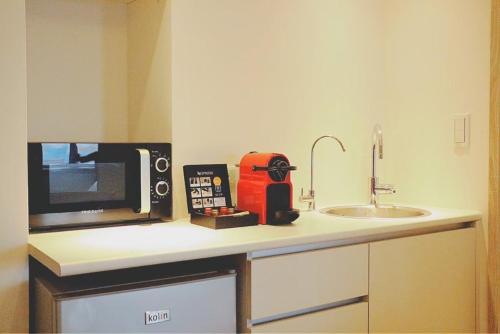 a microwave sitting on a counter next to a sink at MU House in Taipei