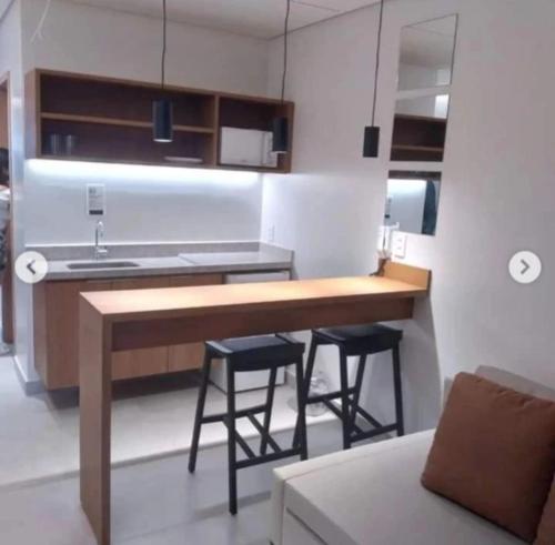 a kitchen with a sink and two stools at Salinas Premium Resort in Salinópolis