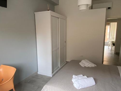ein Schlafzimmer mit einem weißen Schrank und Handtüchern auf einem Bett in der Unterkunft Domus Dotta New in Bologna