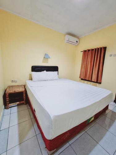 1 dormitorio con 1 cama blanca grande en una habitación en Pandu Homestay Mandalika Lombok, en Kuta Lombok
