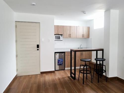 a kitchen with a counter and stools in a room at Venue Studios in Lima