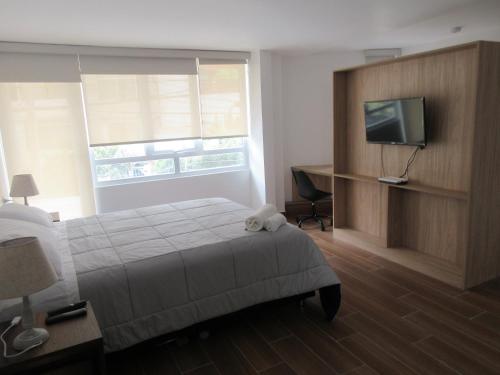 a bedroom with a bed and a flat screen tv at Venue Studios in Lima