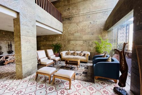 a lobby with couches and chairs in a building at Swarga Suites Bali Berawa, Marclan Collection in Canggu