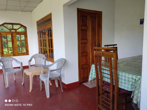a room with a table and chairs and a bed at GREENISH INN (ROOMS) in Nanu Oya