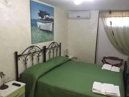 マリーナ・ディ・マンカヴェルサにあるBaccaversa camereのベッドルーム(緑のベッド1台、鏡付)