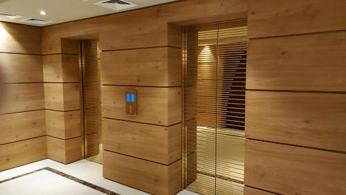 a bathroom with wooden walls and a walk in shower at Dreamland deluxe apartment in Chakvi