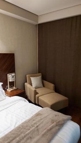 a hotel room with a bed and a chair at Dreamland deluxe apartment in Chakvi