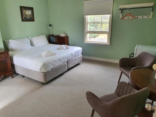 a bedroom with a bed and a table and two chairs at Ratho Farm in Bothwell