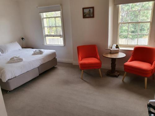 a bedroom with two red chairs and a bed at Ratho Farm in Bothwell