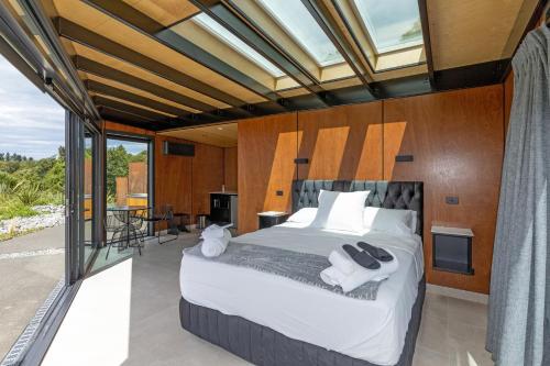 1 dormitorio con 1 cama grande y balcón en Ngā Whare Mānatu, en Geraldine