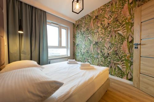 a bedroom with a large bed with a floral wallpaper at Apartament Luxury Two-bedroom in Białystok