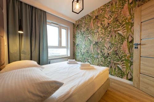 sypialnia z dużym łóżkiem i tapetą w kwiaty w obiekcie Apartament Luxury Two-bedroom w mieście Białystok