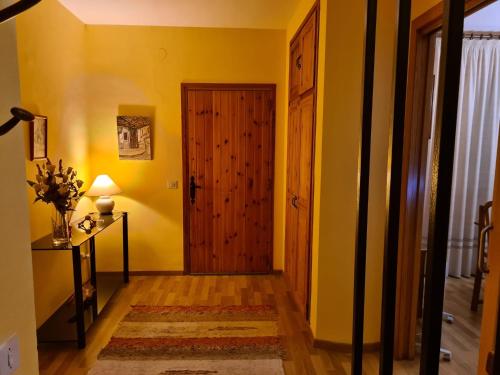 a hallway with yellow walls and a wooden door at Casa centro Gósol in Gósol