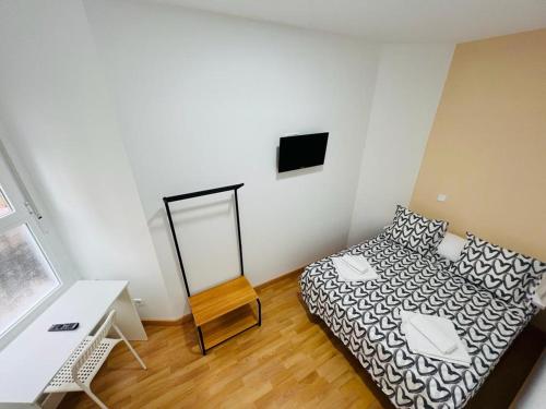 a small bedroom with a bed and a mirror at Hospedaje Puente de Vallecas in Madrid