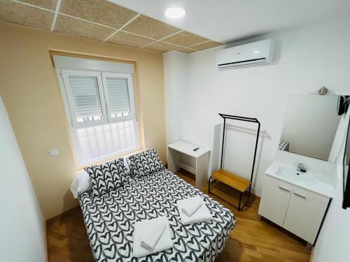 a small room with a bed and a mirror at Hospedaje Puente de Vallecas in Madrid