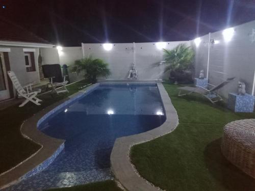 - une piscine au milieu d'une cour la nuit dans l'établissement Petite maison, à Lourdes