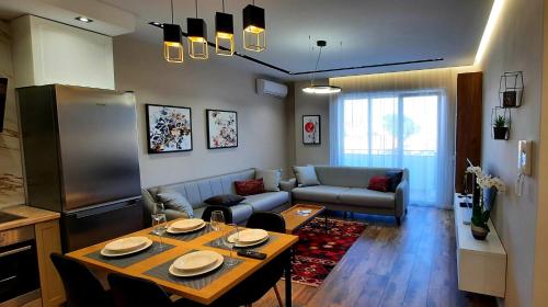 uma sala de estar com uma mesa e um sofá em LUXURY DRIJON APARTMENTS 3j em Shkodër