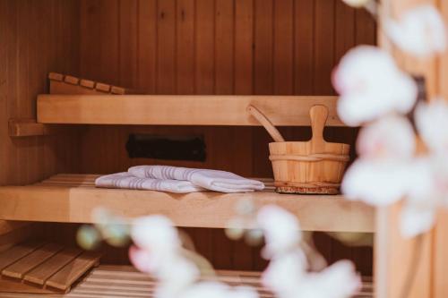 a sauna with a towel and a bucket on a shelf at Wanderhotel Teiserhof in Funes