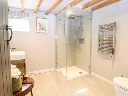 een badkamer met een douche en een glazen deur bij The Old Granary in Pulborough