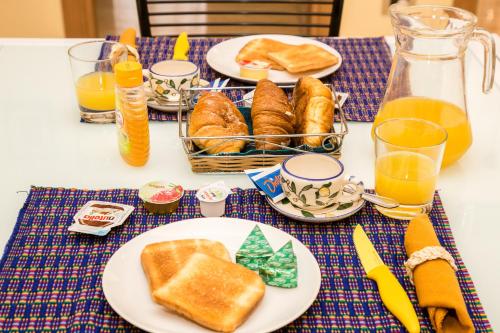 a table topped with plates of bread and orange juice at Trastevere's Friends in Rome