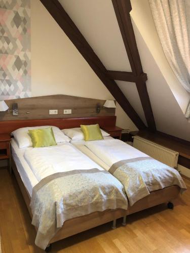 a bedroom with two beds in a attic at Gizella Hotel and Restaurant in Veszprém