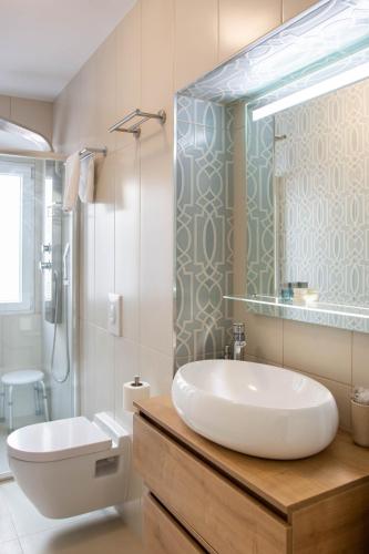 a bathroom with a tub and a sink and a toilet at Stephane City Vibe Suites in Trogir