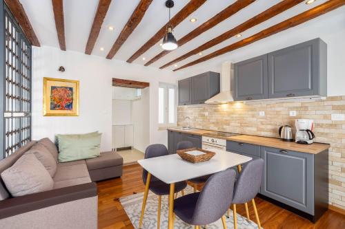 a kitchen and living room with a table and chairs at Stephane City Vibe Suites in Trogir