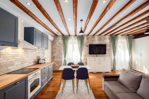 cocina y sala de estar con sofá y mesa en Stephane City Vibe Suites en Trogir
