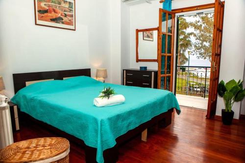 a room with a bed with a blue blanket on it at City center, sea view apartment, Amelia! in Anemómylos