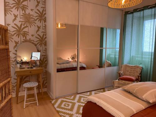 a bedroom with a bed and a desk and a mirror at Lovely apartment in Périgueux in Périgueux