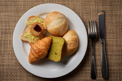 a plate of food with bread and croissants on a table at Hotel Kuu Kyoto in Kyoto