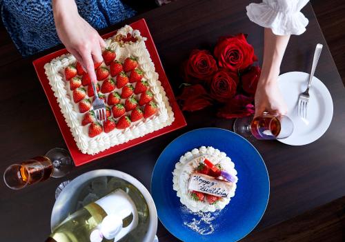 a table with a cake with strawberries on it at Hotel Kuu Kyoto in Kyoto