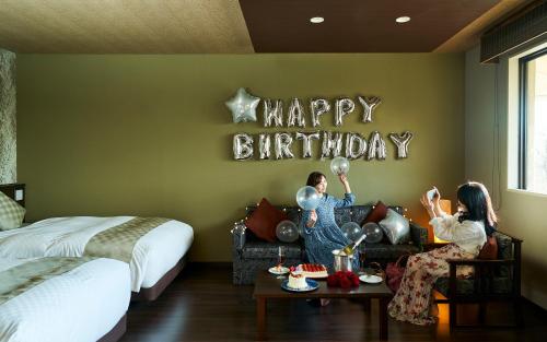 a group of people in a bedroom with a happy birthday sign at Hotel Kuu Kyoto in Kyoto