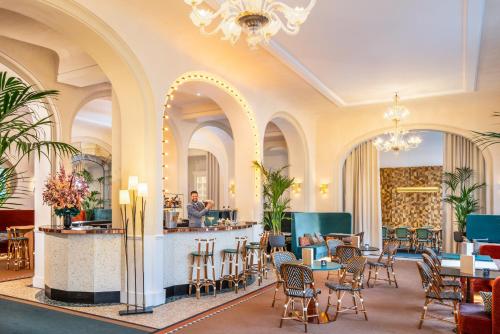 um hall de entrada com mesas e cadeiras e um homem parado num balcão em Holiday Inn Paris - Gare de Lyon Bastille, an IHG Hotel em Paris