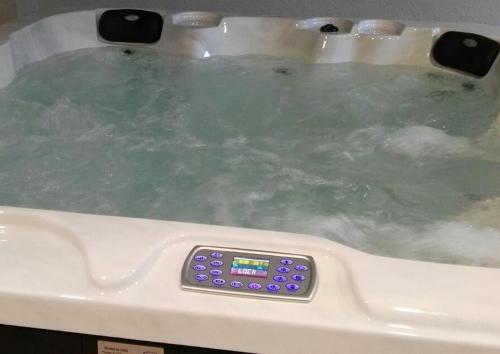 a bath tub filled with water with a remote control at LES FEIXES LLARGUES - max 18 pax in Bolvir