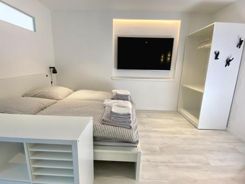 a small bedroom with a bed and a tv at Apartment Schloofschdubb in Fuldatal bei Kassel in Fuldatal
