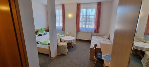 una camera con un letto e due tavoli di Landhaus Adorf a Bad Elster
