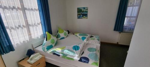 a small room with a bed with pillows on it at Gasthof Landhaus Adorf in Bad Elster