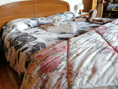 a bed with a blanket and pillows on it at Chalet del paese Incantato comune di Moncenisio in Moncenisio