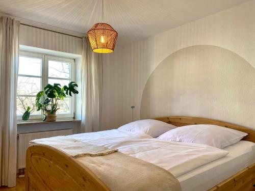 una camera da letto con un grande letto con lenzuola bianche e una finestra di Best Butler Boho Boutique City Apartment Netflix a Füssen