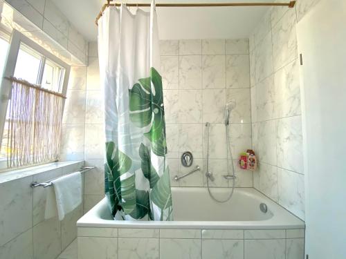a bathroom with a bath tub with a plant in it at Best Butler Boho Boutique City Apartment Netflix in Füssen