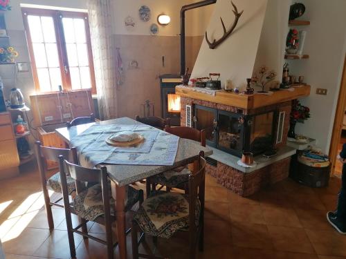 een eetkamer met een tafel en een open haard bij Chalet del paese Incantato in Moncenisio