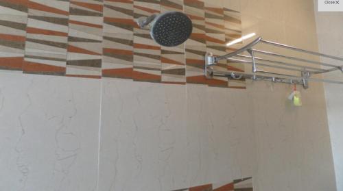 a shower with a shower head on a wall at Hotel SaiPrasad Executive Solapur in Solapur