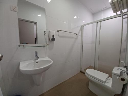 a white bathroom with a sink and a toilet at KT Chinatown Lodge in Kuala Terengganu