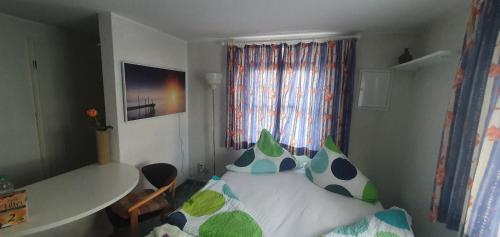 ein kleines Schlafzimmer mit einem Bett und einem Fenster in der Unterkunft Miniferienhaus Bad Elster in Bad Elster