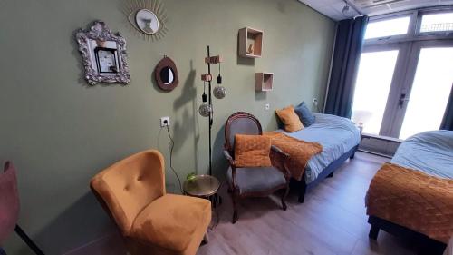 een slaapkamer met een bed en een stoel bij Gastenverblijf Nummer 1 Sommelsdijk in Sommelsdijk