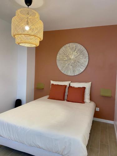 - une chambre avec un lit blanc aux murs orange dans l'établissement La ROSERAIE, à Mont-de-Marsan